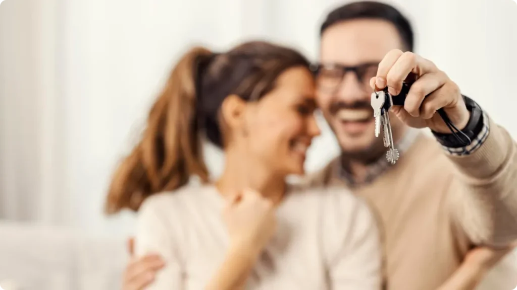 Couple Smiling And Showing Off Their New House Keys