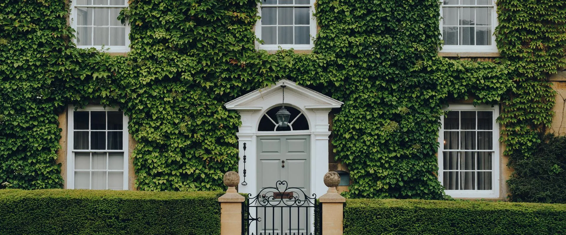 Topheader Facade Of A Traditional House In UK Covered With Ivy