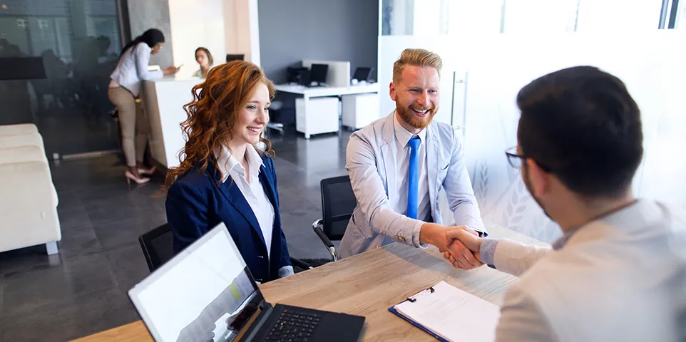 Couple Talking To Loan Officer And Shaking Hands